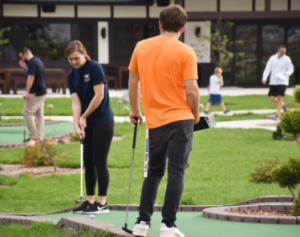 Boy and girl playing miniature golf